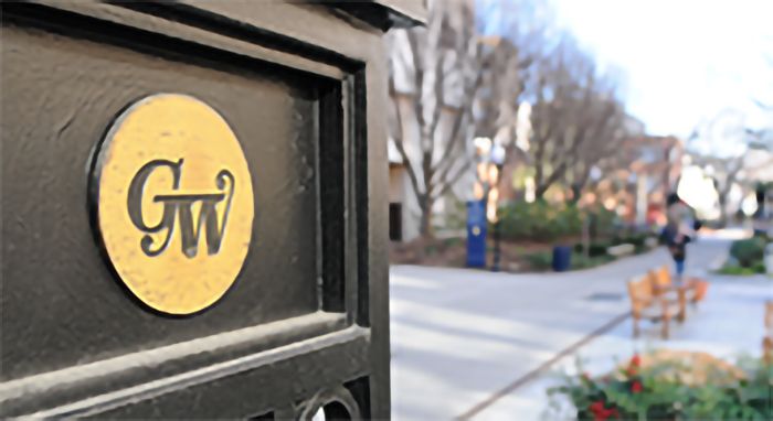 Gate on campus with "GW" emblem 